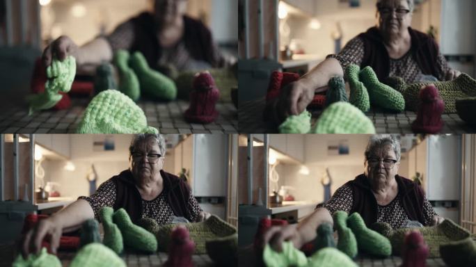 肥胖老年妇女在家桌上整理各种针织品