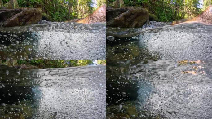 高山河流中最纯净的气泡水。半水下慢动作拍摄的河流在绿色的森林和山脉。石头之间有小瀑布的小溪