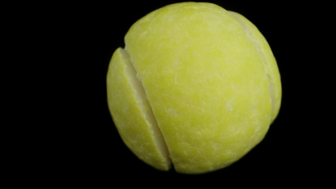 网球形状的软糖。在黑色背景上模拟向下坠落。多莉微距变焦。