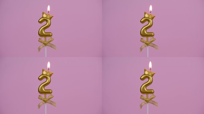 金色生日蜡烛燃烧在粉色，2号。