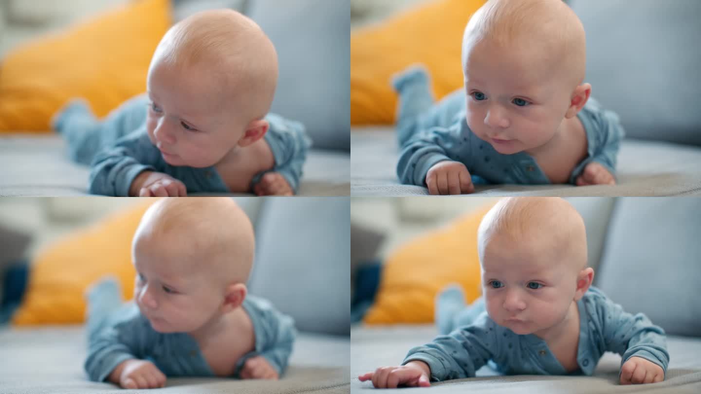 宝宝的俯卧时间。一个蓝眼睛的小男孩趴在肚子上的特写