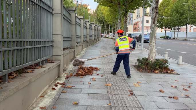 秋季清洁工清扫大街上的落叶