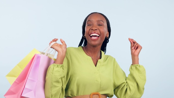 快乐的黑人妇女，购物袋和跳舞庆祝，销售或折扣背景的工作室。兴奋的非洲女性或购物者开心地微笑着在实体空