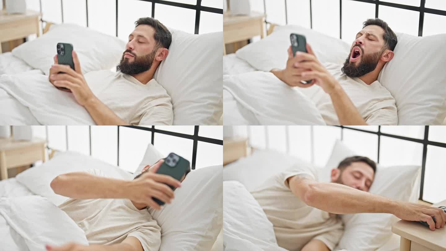 年轻的西班牙裔男子躺在床上，把智能手机放在桌子上，在卧室睡觉