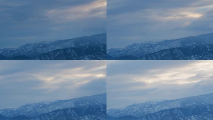 阴云在冬天的雪峰上移动。暴风雪中被雪覆盖的山。间隔拍摄。