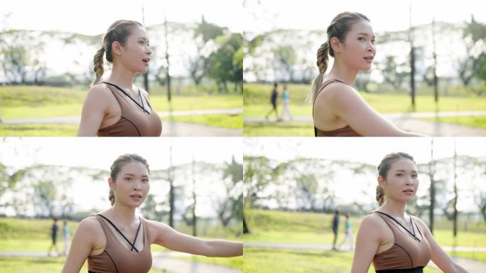侧视图:一个穿着运动胸罩的亚洲妇女在绿色的公园里散步和跑步。健康女性在工作之余进行户外运动。放松时间