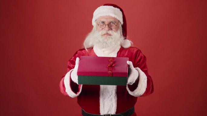 圣诞老人拿着红盒子里系着丝带的礼物