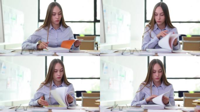 女实习经理学生在办公室翻阅工作日志