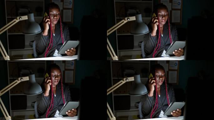 非裔美国女老板用智能手机谈生意，在办公室内部用触控板工作
