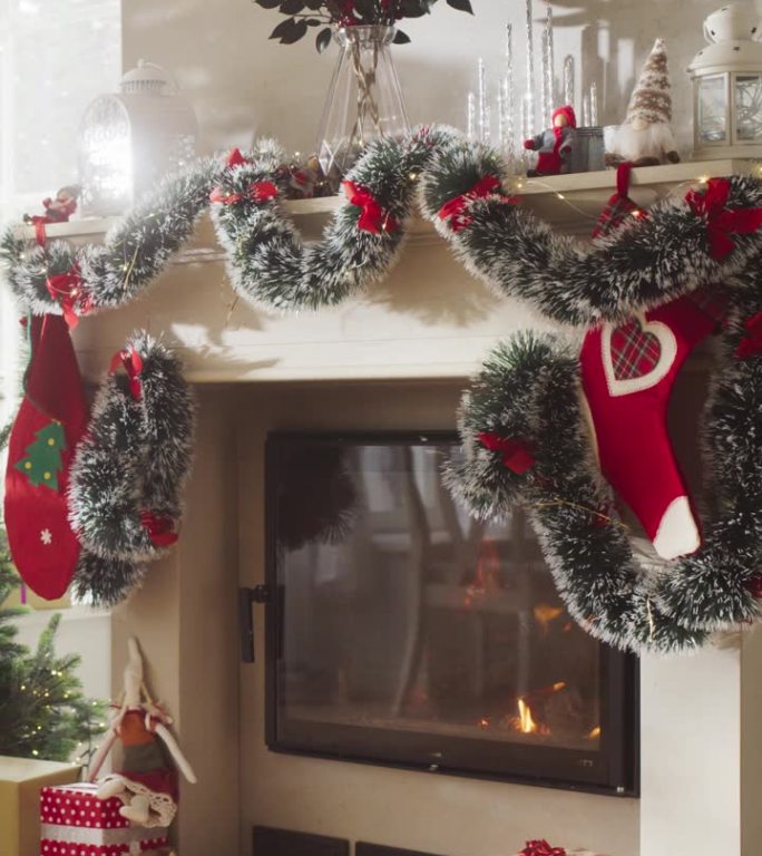 垂直屏幕:和平的雪圣诞节早晨:空镜头装饰的角落在现代的房子与圣诞树，壁炉和礼物。一个家庭庆祝节日的家