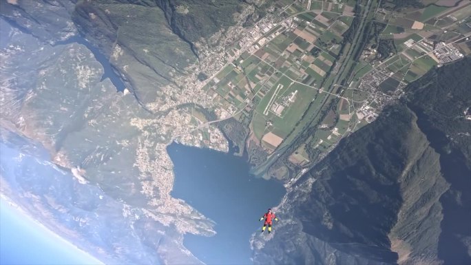 在阳光明媚的日子里，在马焦雷湖上空跳伞，俯瞰阿尔卑斯山