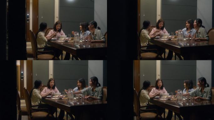 亚洲家庭吃中国菜，晚上坐在家外后院的餐桌上吃晚餐。多代同堂的家庭一起享受消费。