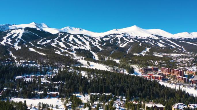 空中无人机拍摄的令人惊叹的山坡滑雪斜坡视频。许多冬季运动的小径覆盖在山峰上的厚粉秀