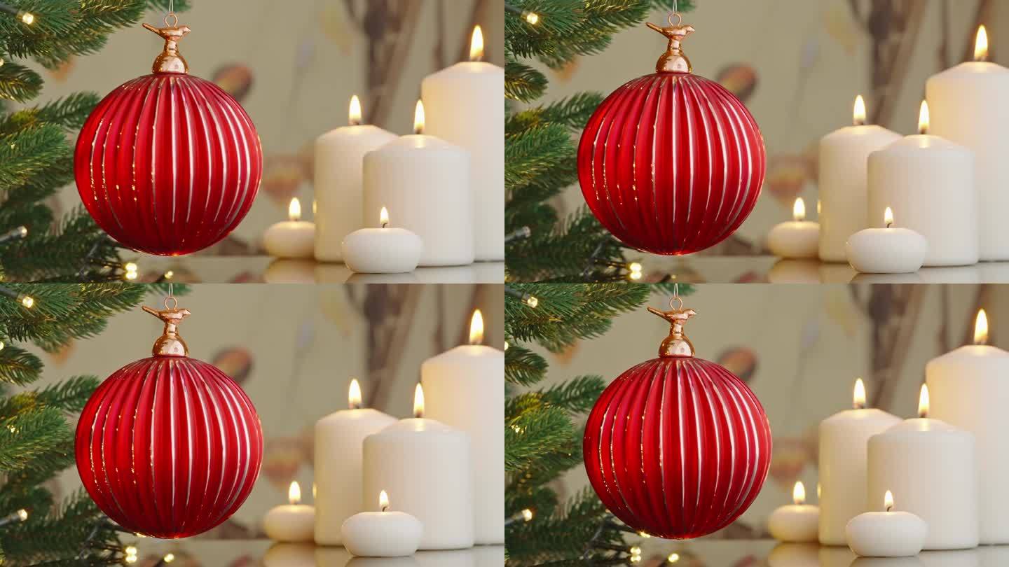 圣诞树树枝上的红色玻璃球特写装饰着燃烧的蜡烛散景，闪烁的灯泡背景上的花环。圣诞节的概念。庆祝新年快乐