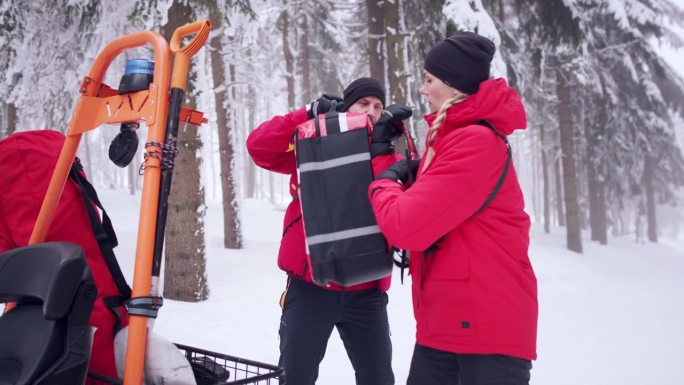 山区救援服务队的救护人员在森林中进行冬季户外手术。