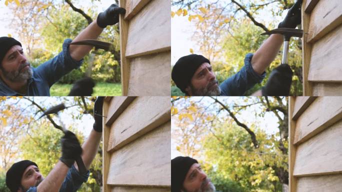 大胡子男子在外墙钉木制挡风板