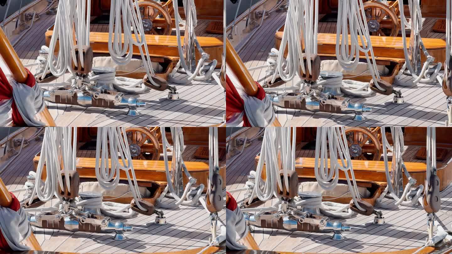 古色古味的护卫舰在阳光明媚的日子里的装备，木制的方向盘，许多绳索，木制的甲板，船在波浪上的岩石，旗帜