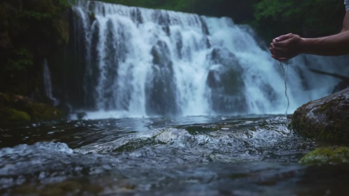 SLO莫曼正在饮用博欣卡河的水，背景是瀑布