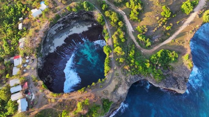 破碎海滩的移动海浪日落场景是巴厘岛努沙佩尼达岛最著名的观光景点之一。这是岩石中形成的一个神奇的马蹄形
