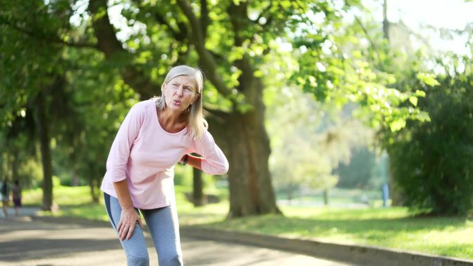 一位活跃的白发老妇人在城市公园跑步时突发心脏病