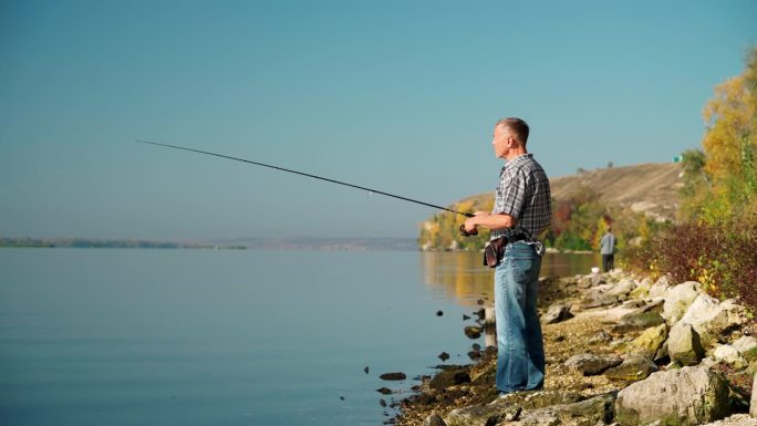 一个成年男子用纺丝竿钓鱼的全景图。