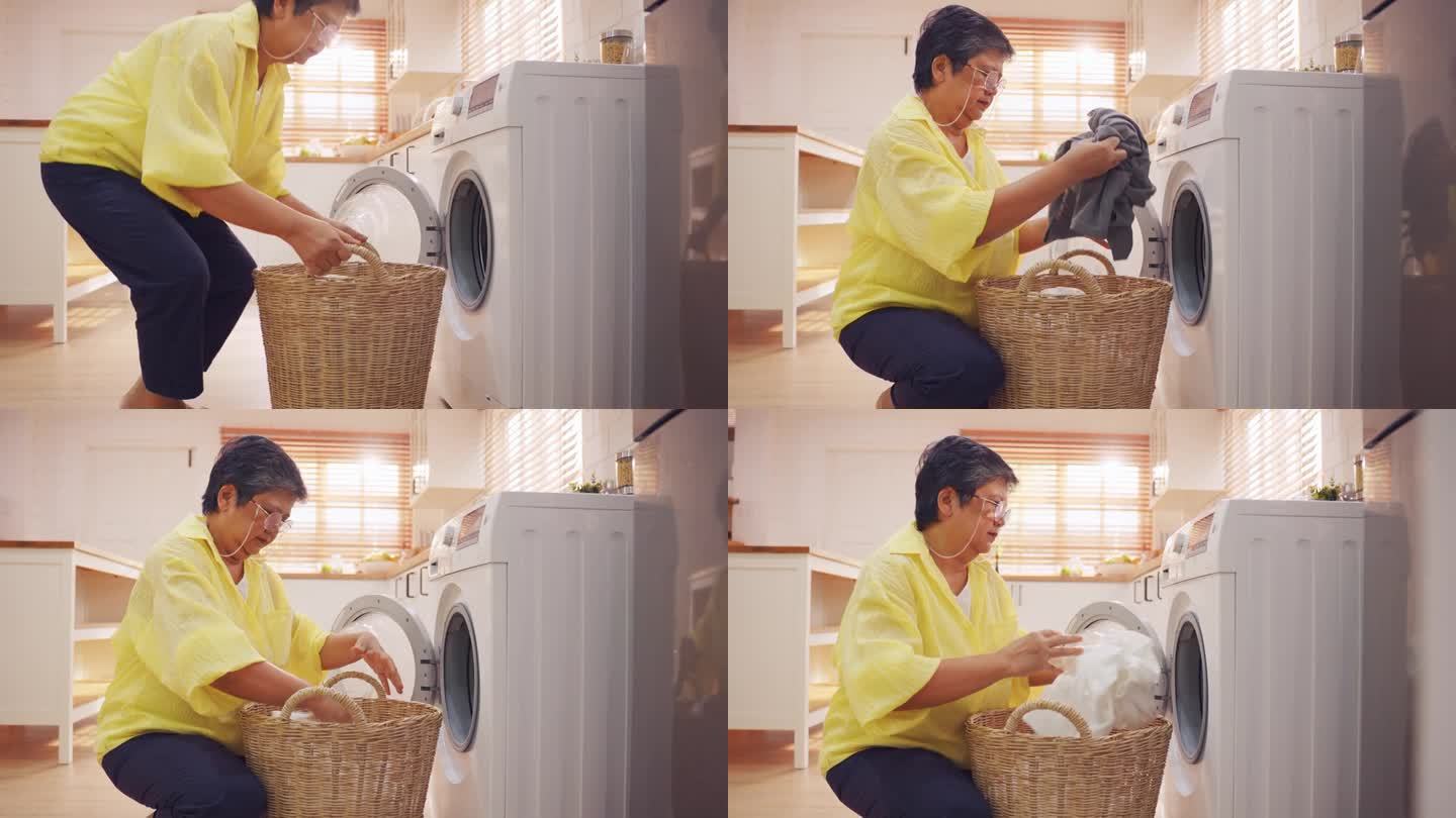 亚洲老年妇女把脏衣服放进洗衣机。有魅力的成熟的老管家清洁工，在家里用洗衣机洗衣服时感到很开心。家政概