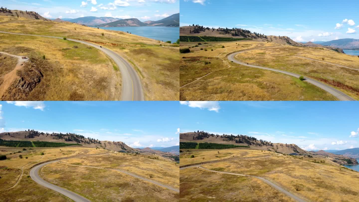 骑哈雷戴维森直升机摩托车，在公路旅行兜风，沿着风景秀丽的路线与湖景。弯弯曲曲，蓝天和开阔的道路。弗农