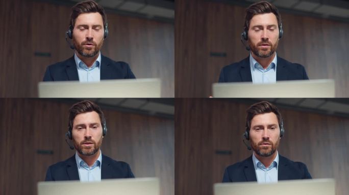 穿着西装的自信的白人男子在工作场所使用无线耳机和笔记本电脑进行视频会议。留胡子的英俊男企业家在现代办