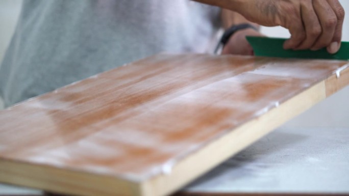 专业技术人员在胶合板上涂胶水，制作帆布相框