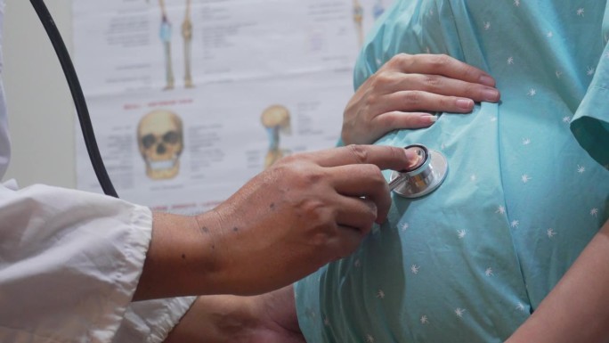 一名男医生在妇产中心会诊期间检查他怀孕的病人。