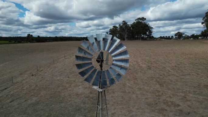 在多云的日子里，玛格丽特河地区的农场上旋转风车的空中向后拍摄