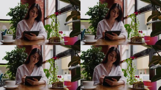 在咖啡馆用平板电脑上网的年轻成年女性，忙碌的女商人的肖像