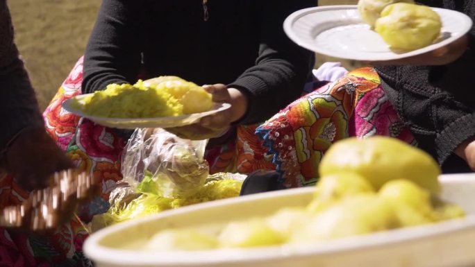 秘鲁万卡约的早晨，在塔塔香提节上。妇女们把传统的黄米饭放在盘子里。