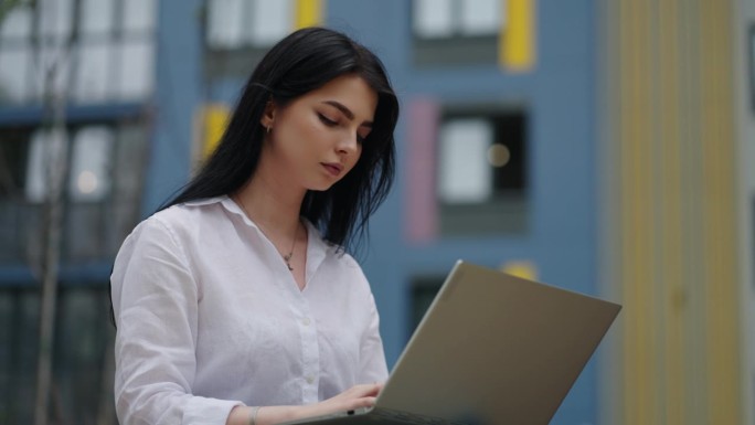 自由职业者女性在户外使用笔记本电脑，女性工作者使用笔记本电脑进行交流