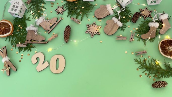 木制圣诞玩具，土花树枝和干橙子片，绿色背景上有数字2024。圣诞装饰品。平的。环保理念