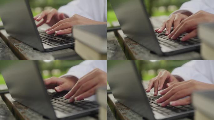 女学生在公园里用笔记本电脑打字，手和键盘的特写