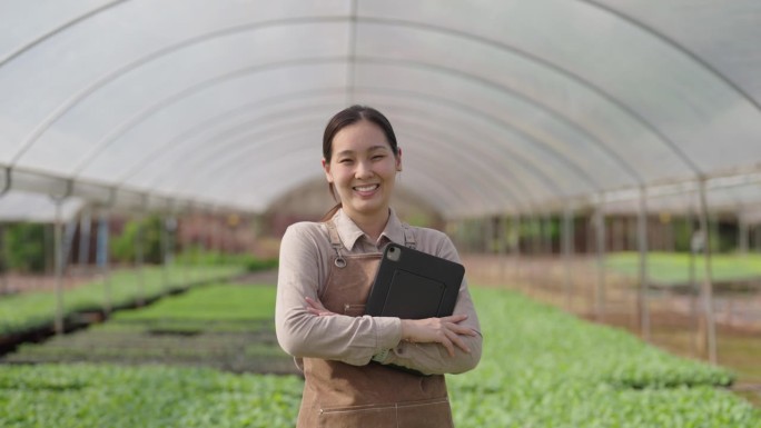 自信的女农民站在温室里