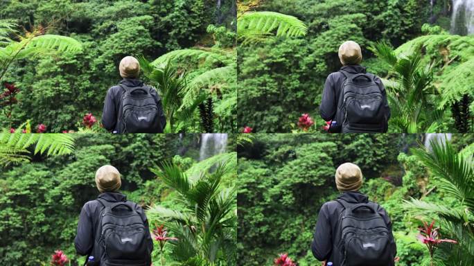 成年男子在绿色自然中前往森林瀑布。年轻的不认识的人走到瀑布的旅行目的地。海岛天堂景观中个人旅行的生活