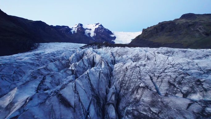 鸟瞰图:在冰川蜿蜒的小径上，可以看到深深的裂缝和锯齿状的冰层，这是气候变化对这个自然奇观不断移动和转