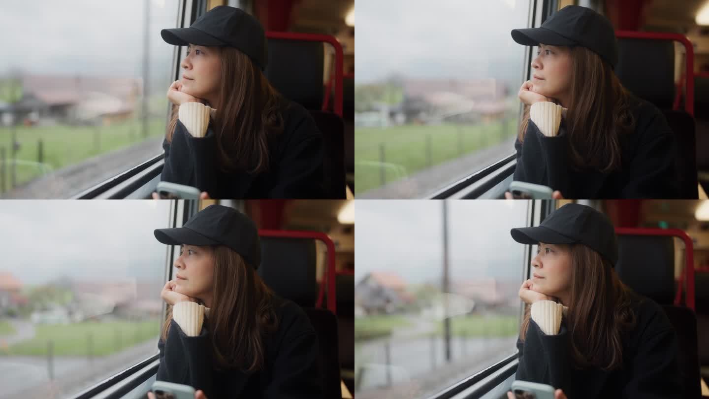 美丽的女游客坐在火车的窗边，透过窗户看风景