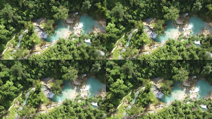 游客在茂密的丛林小径上前往川山瀑布，在多层瀑布泻湖中游泳。空中
