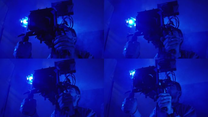 摄影师在蓝光和烟雾中用专业相机拍摄