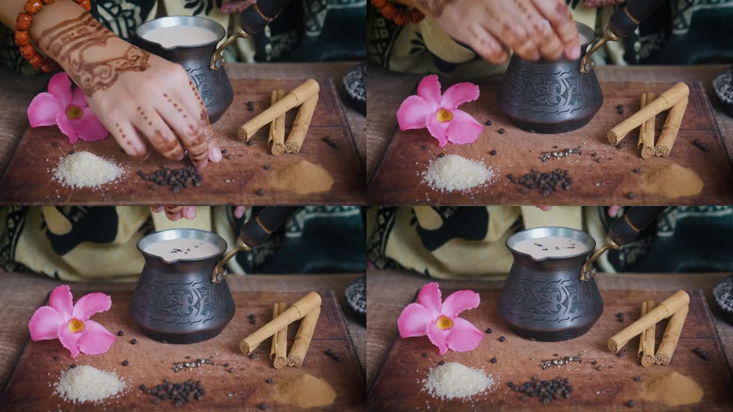 印度妇女用手在制作玛沙拉茶时加入香料。关闭了。