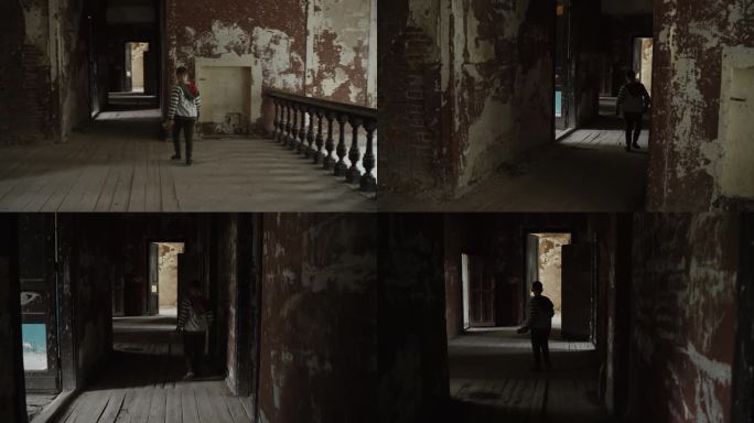 男孩走在倒塌的废弃建筑的走廊上，稳定了摄像机。