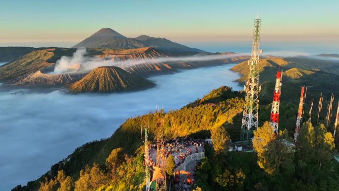 空中无人机拍摄的印尼爪哇岛东爪哇岛腾格里火山口喷发火山Bromo火山的日出场景，周围有云、雾和烟，还