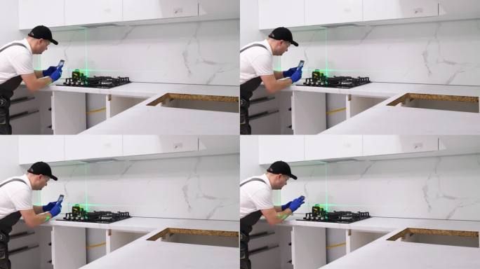 师傅在安装厨房家具时使用电子激光。附件安装