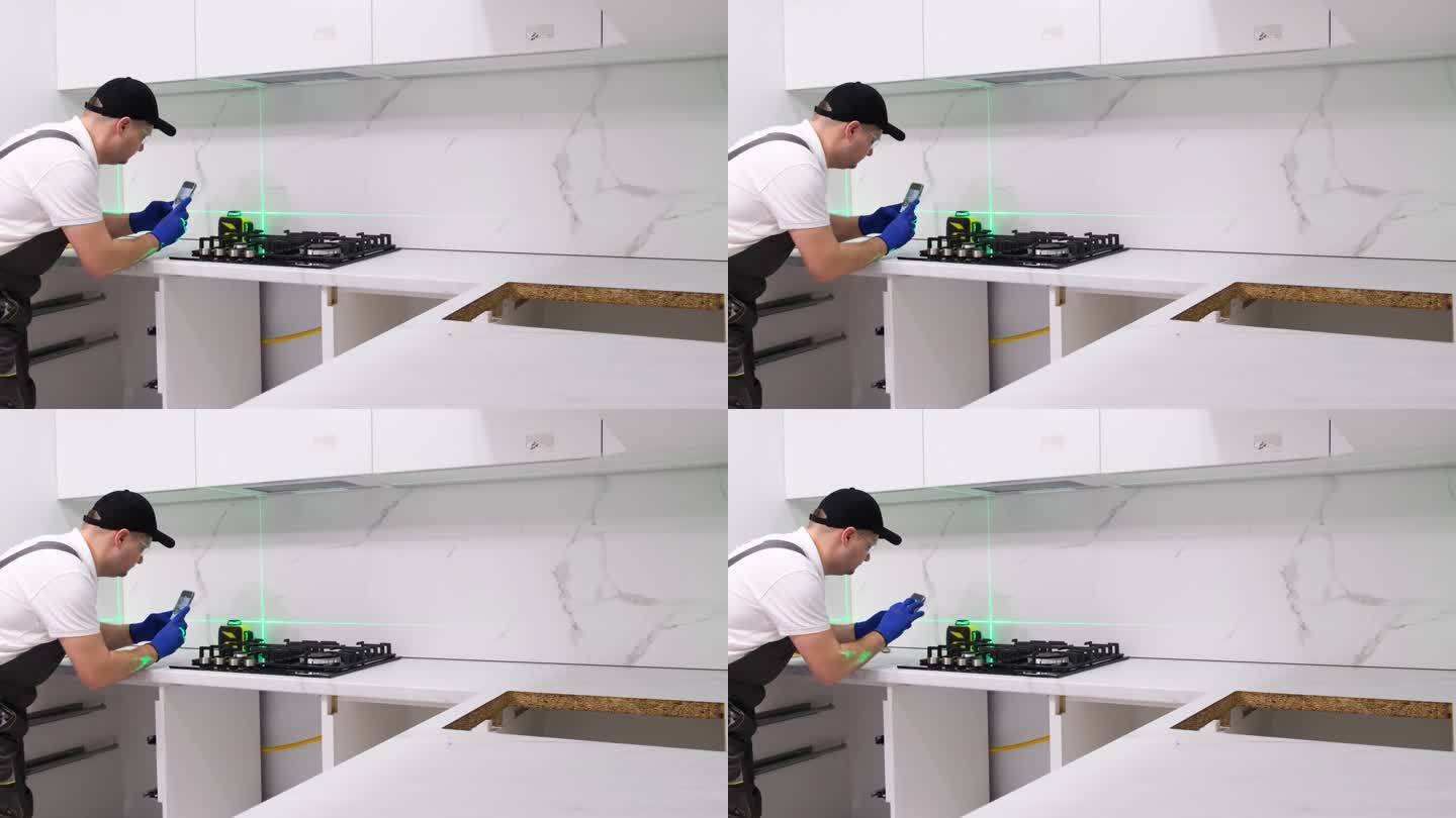 师傅在安装厨房家具时使用电子激光。附件安装