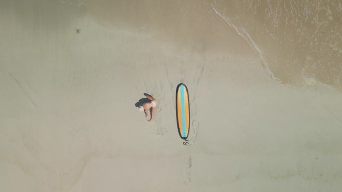 正上方是沙滩上拿着冲浪板的女人