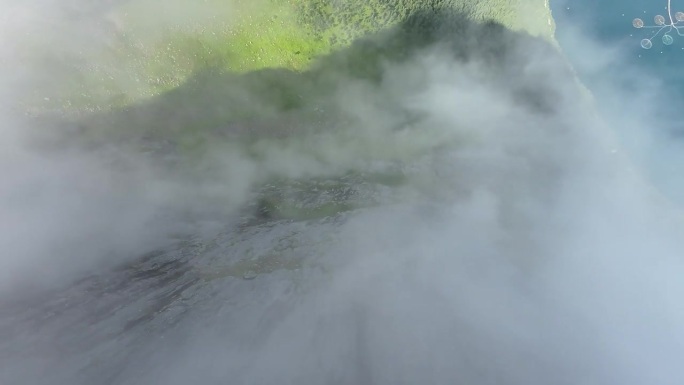 一架FPV无人机大胆地穿过薄雾，从一座巨大的山峰陡峭的垂直表面俯冲下来，捕捉到穿越云层的超现实下降