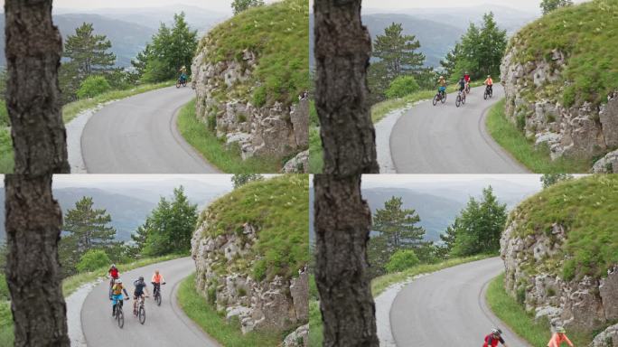 四个山地自行车手骑在柏油山路上